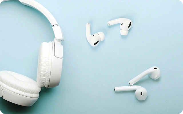 Trīs pāri baltu bezvadu austiņu: labajā pusē 2 austiņu pāri ar baltām In-ear austiņām, kreisajā pusē baltas On-ear austiņas.