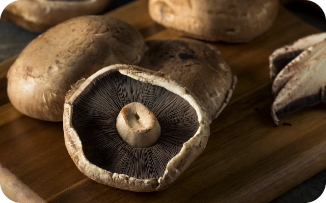 Portobello sēnes uz koka dēļa.