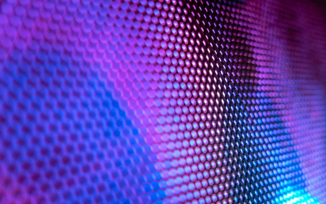 Tuvplāns ar krāsainu, pikseļotu virsmu, kas veidota no sešstūrainiem elementiem un izgaismota violetos un zilos toņos.