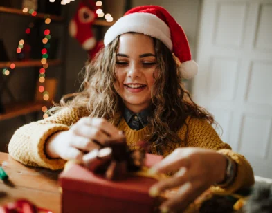 Snieg sniegs. Divi sunīši sēž piesnigušā pļavā. Vienam sunim galvā sarkana cepure ar bumbuli, otram sunim zila cepure ar pušķišiem.